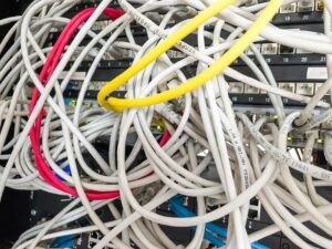 Ein chaotisch verkabelter Netzwerkverteiler mit Kabelgewirr